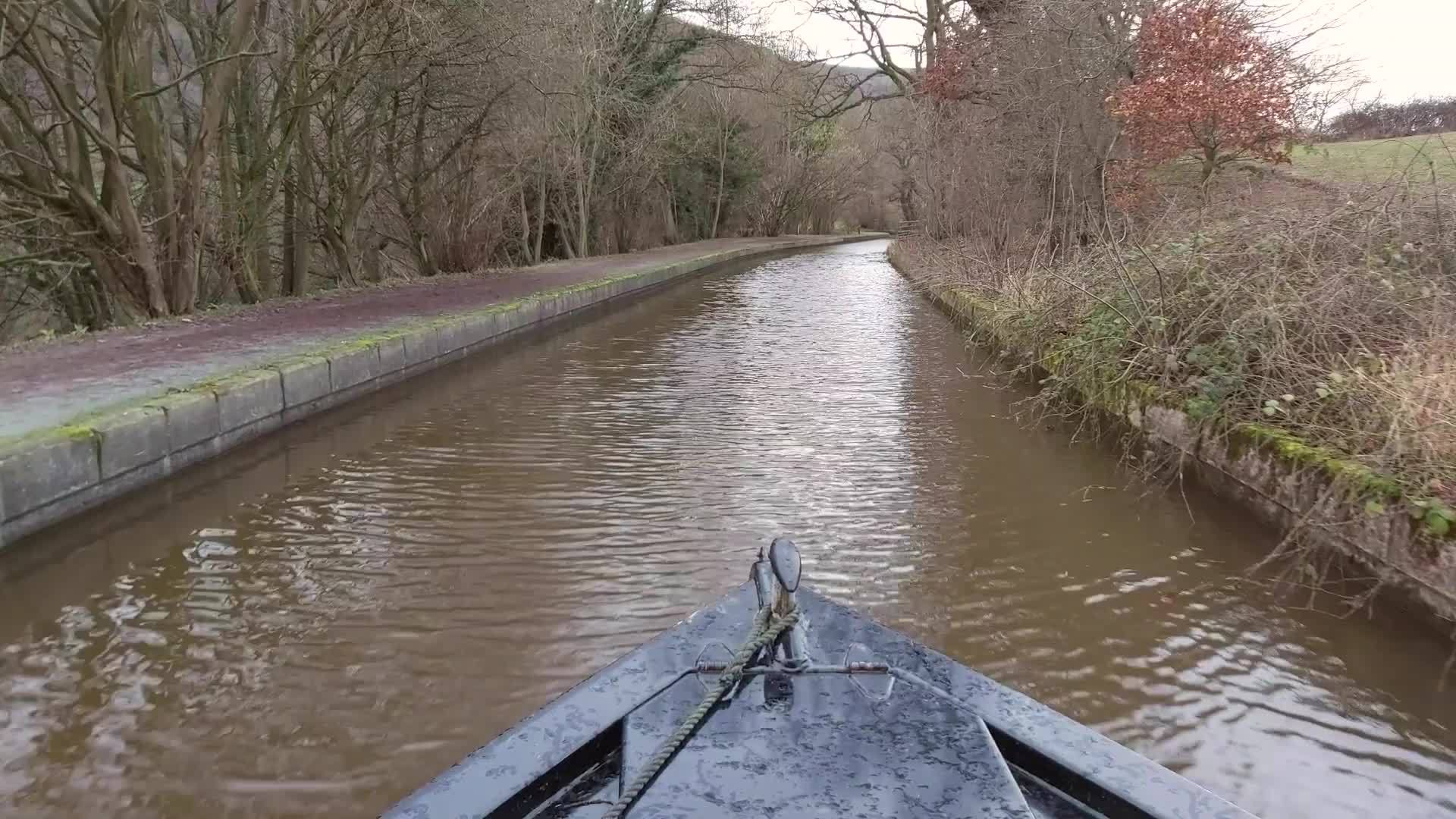 一艘狭窄的船在农村的一条英属运河上航行视频的预览图