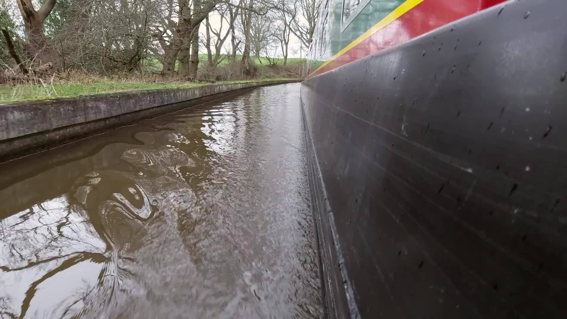 一艘狭窄的船在农村的一条英属运河上航行视频的预览图