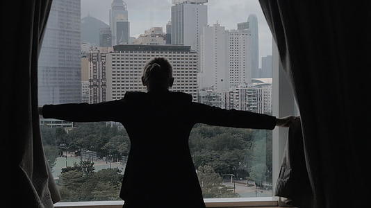 女人在香港风景中慢慢地打开窗帘视频的预览图