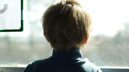 小男孩看着火车窗外的公共汽车或小男孩视频的预览图