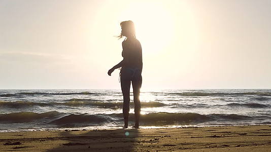 比基尼女孩日落时站在海滩上的慢动作记录是120英尺视频的预览图