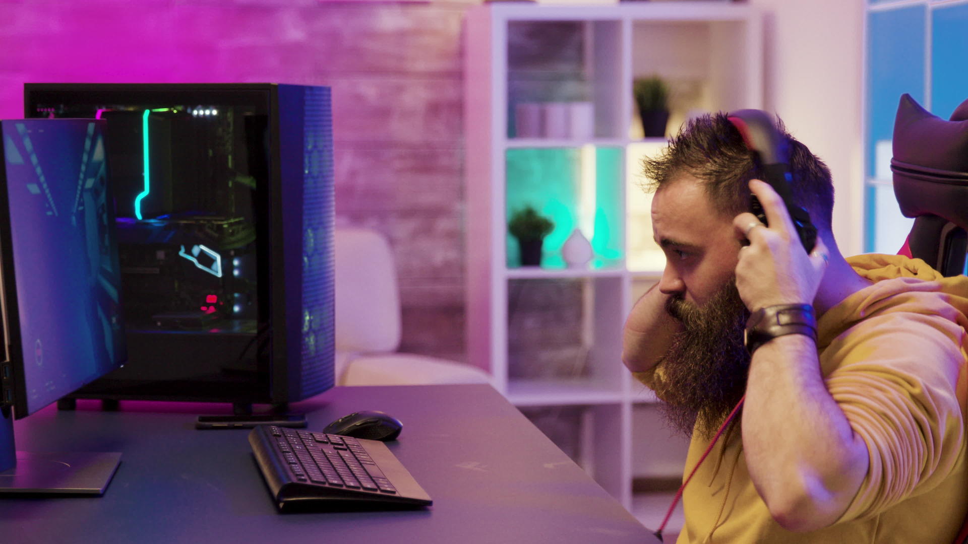 集中的男人在房间里使用Pc玩电子游戏视频的预览图