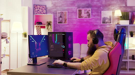 成功的男人在电脑上玩网络电子游戏视频的预览图