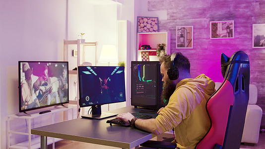 一个成功的男人在一个丰富多彩的房间里在网上玩电子游戏视频的预览图