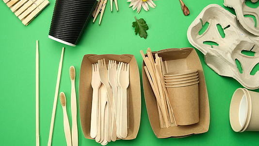 各种可回收材料由一次性纸杯和绿色背景的木叉制成视频的预览图