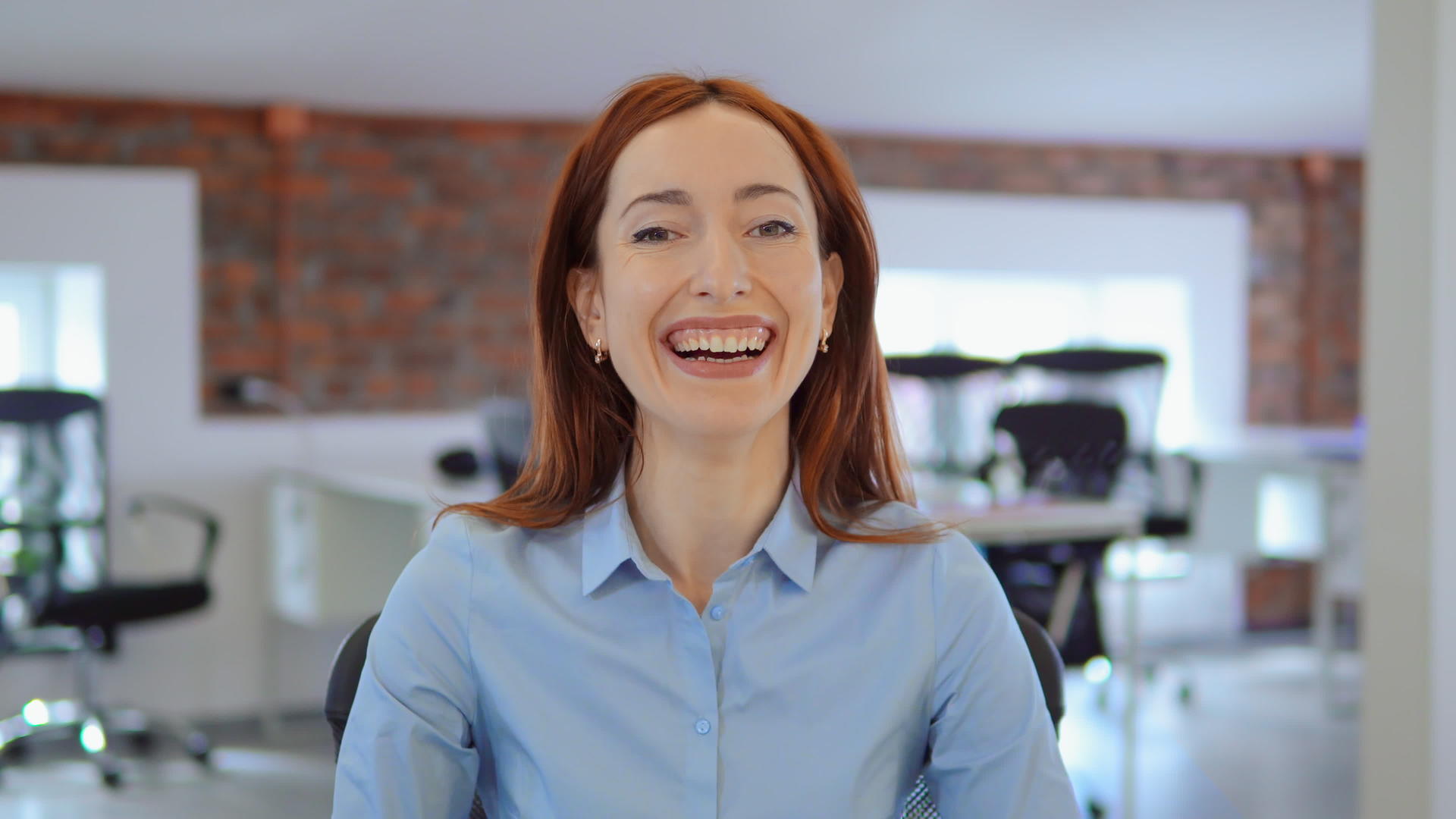 快乐的红发女商人在工作时微笑视频的预览图