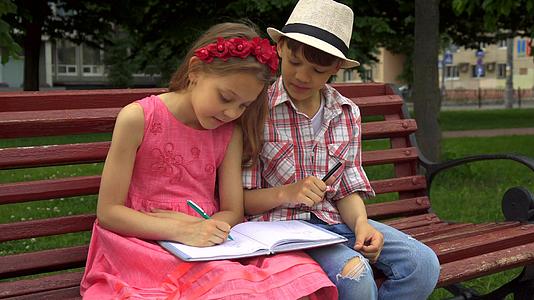 小女孩画在笔记本的一页上她的朋友画在另一页上视频的预览图