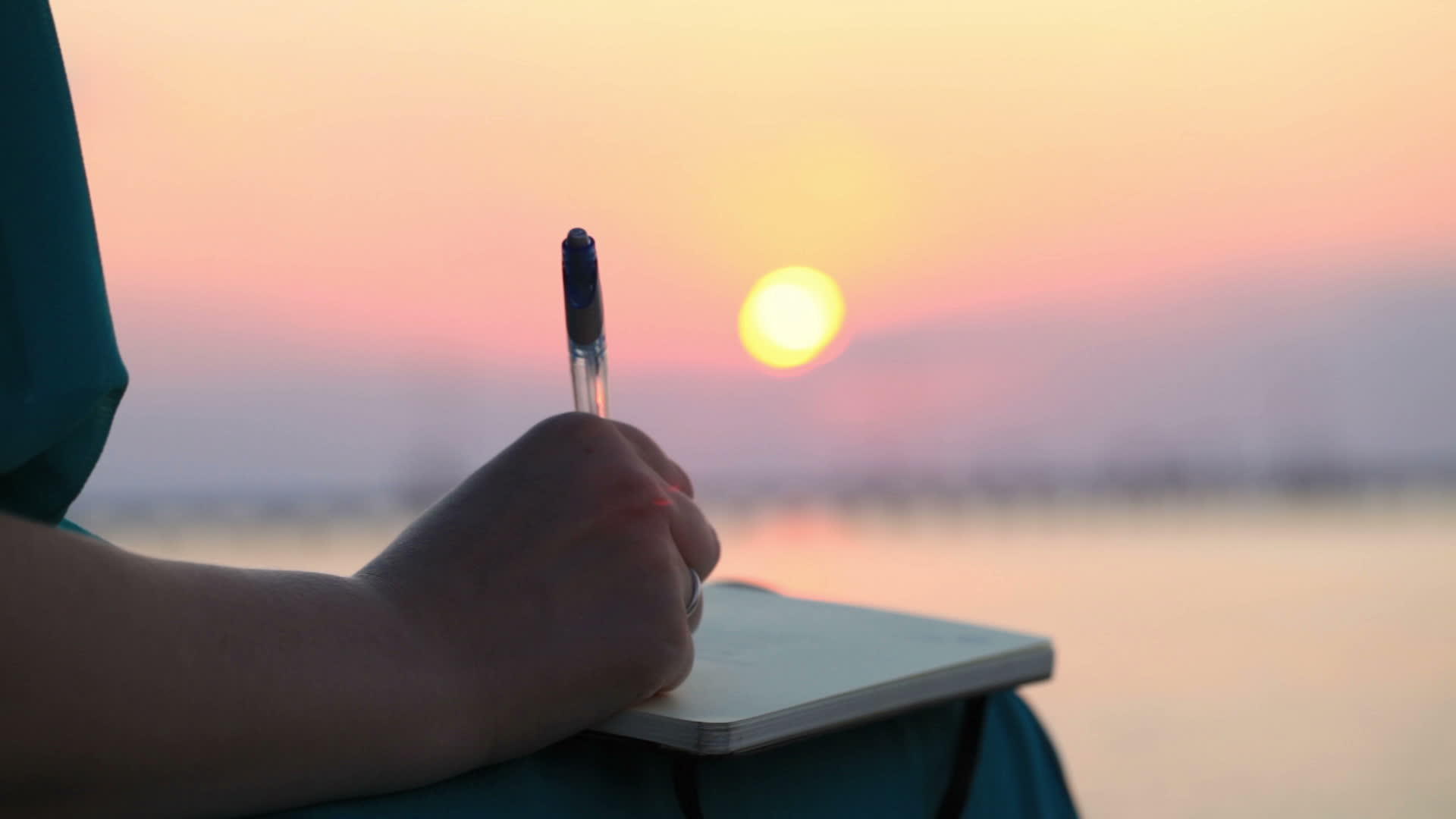 女人在日落时写日记视频的预览图