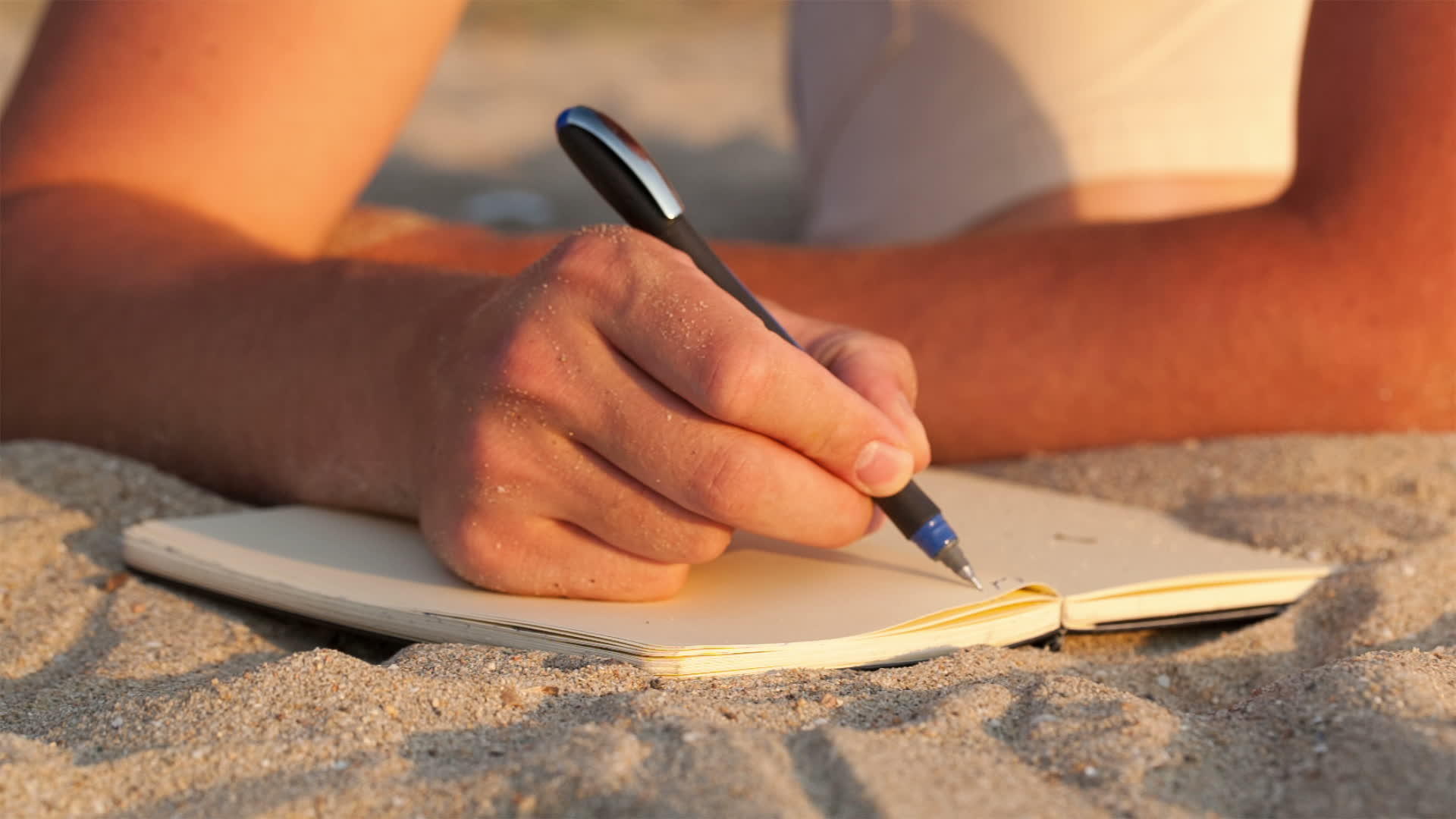 在海滩上写日记的人视频的预览图