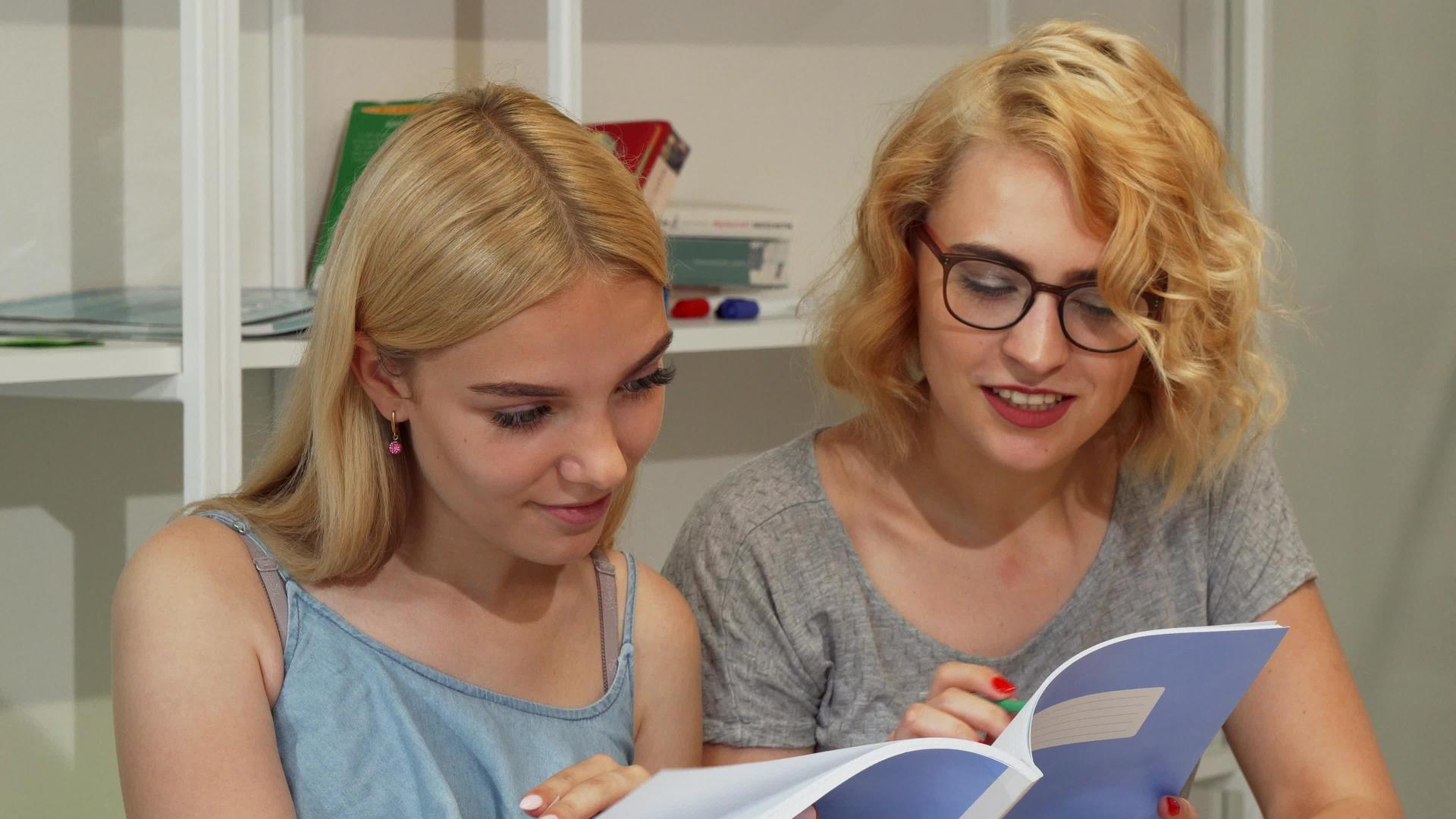 大学礼堂阅读教科书的年轻女学生人数视频的预览图