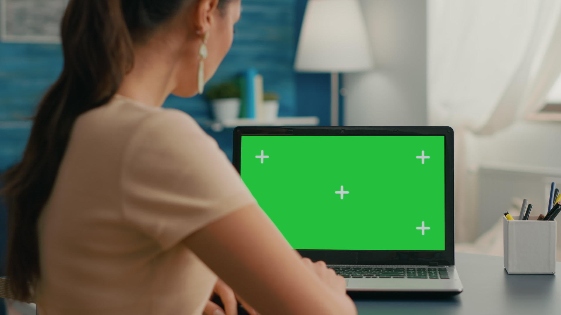 以绿色屏幕为模型看笔记本电脑的女性背部镜头视频的预览图
