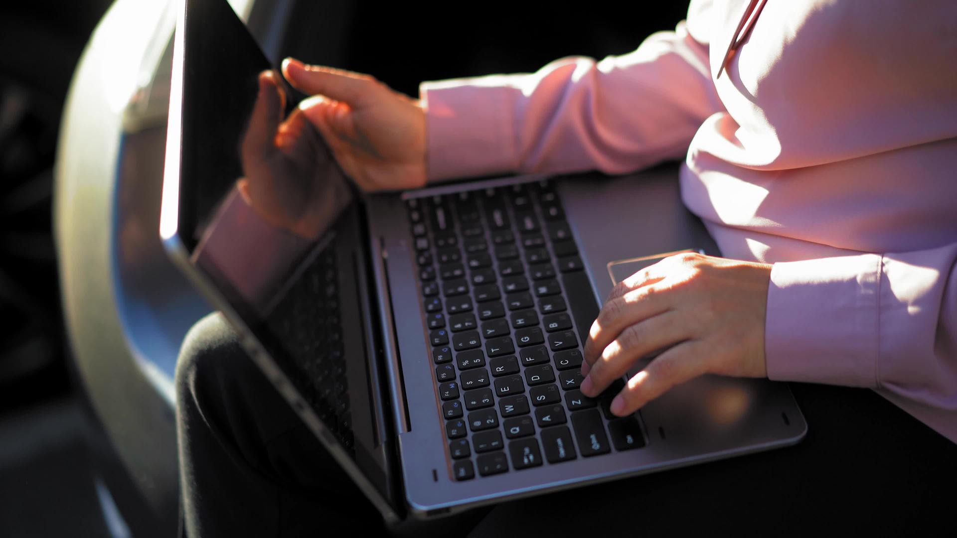 女商人在外面的笔记本电脑上打字视频的预览图
