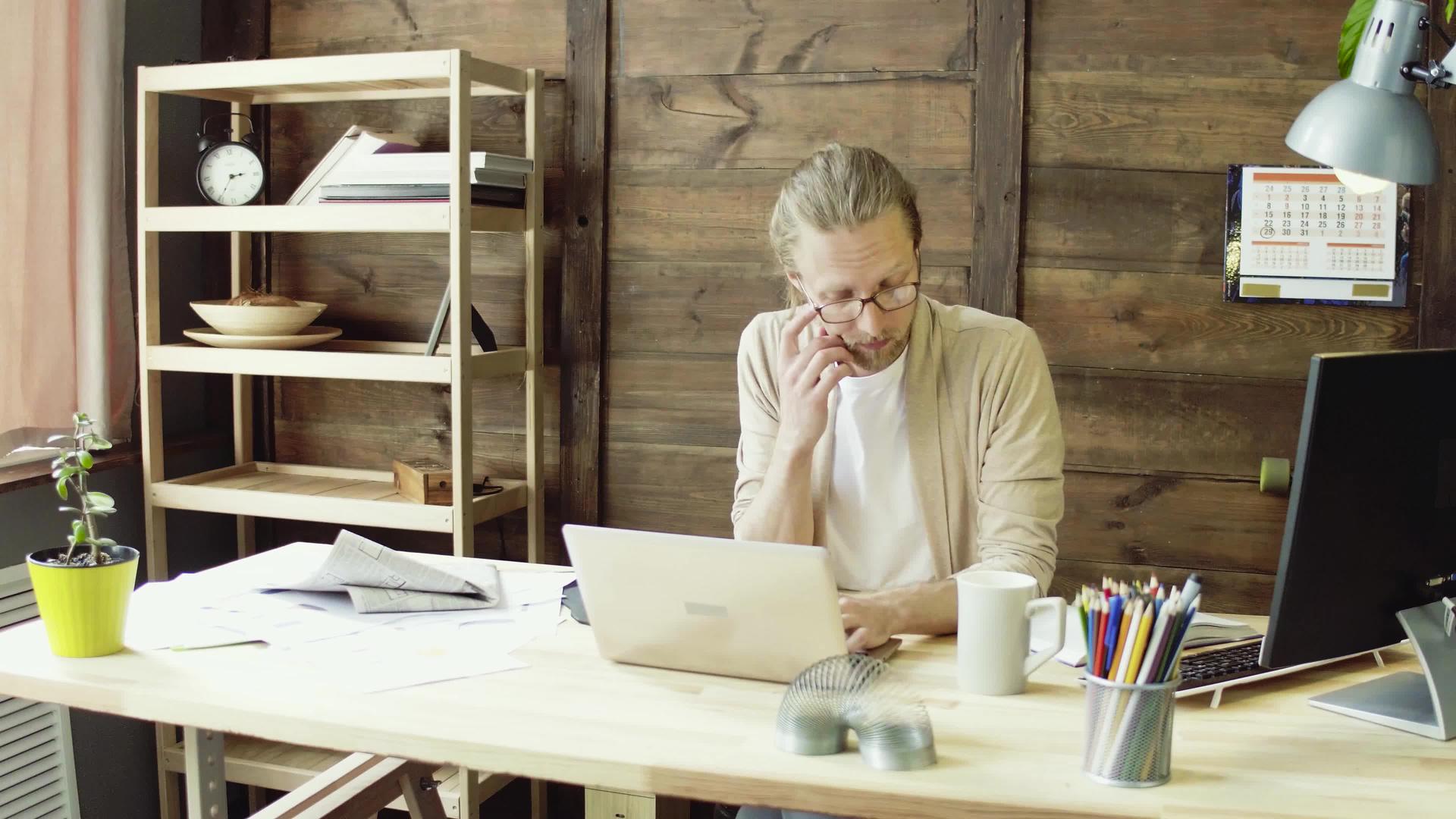 自由自由职业者在家用笔记本电脑工作视频的预览图
