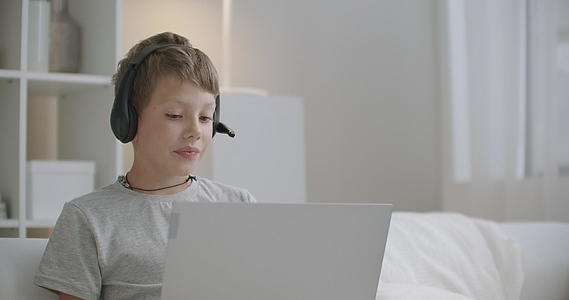 客厅里有笔记本电脑的小男孩通过视频电话主动和正面视频的预览图