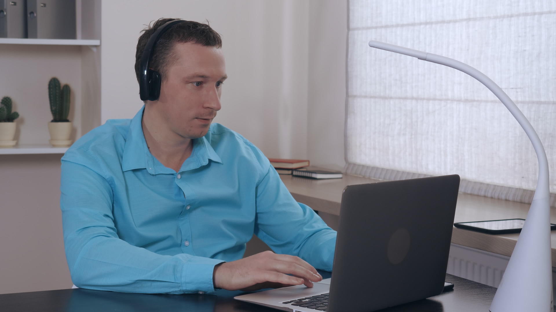 男子在室内笔记本电脑上浏览互联网肖像视频的预览图