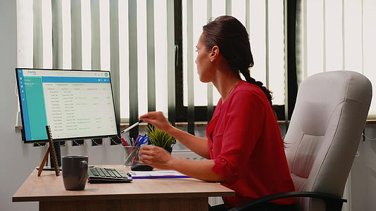 在电脑上加班时做笔记的女商人视频的预览图