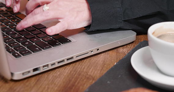 在笔记本电脑键盘上打字的女性手靠近镜头视频的预览图