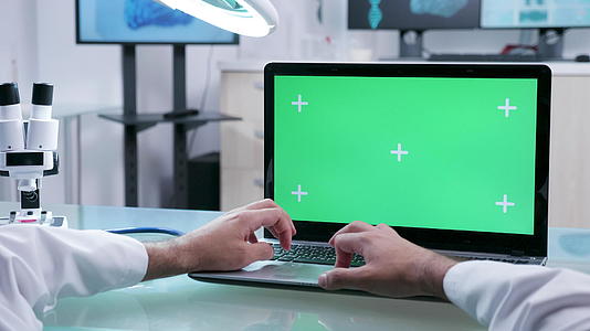 男性从业者用绿色屏幕在笔记本电脑上工作视频的预览图