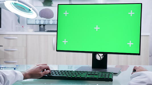 男医生在电脑上用模拟绿屏打字视频的预览图