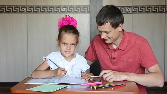 一年级的女孩抓住他的头说在教皇的帮助下做作业时她用铅笔指着他视频的预览图