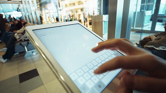 女性在机场或候车室使用平板电脑视频的预览图