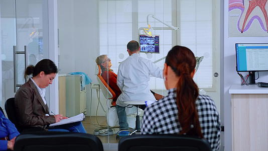 病人坐在候诊室的椅子上口腔诊所里坐满了病人视频的预览图