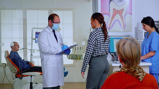 在剪贴板上做笔记的女性接受了牙医的询问视频的预览图