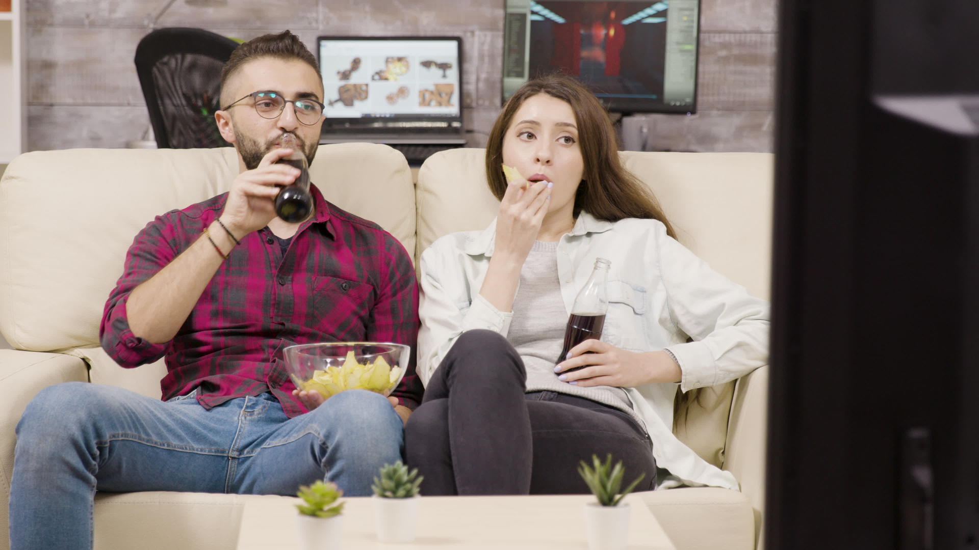 年轻美丽的夫妇坐在沙发上视频的预览图