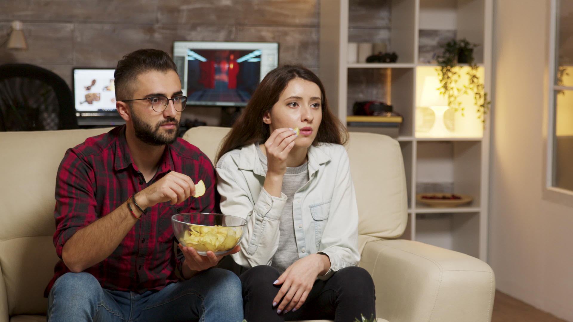Caucasiansian年轻夫妇一边看电视一边吃饭视频的预览图