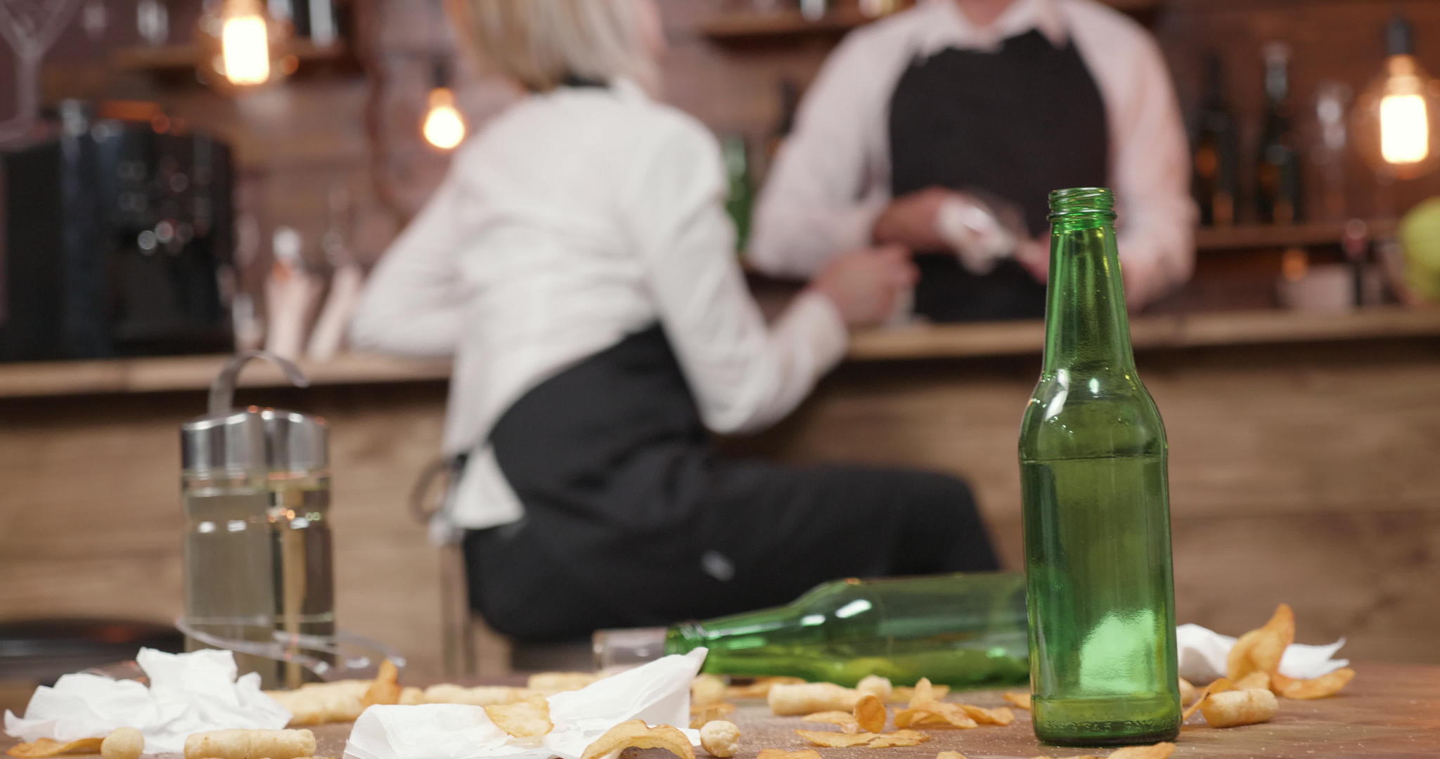 一张空啤酒瓶在一个封闭的酒吧里的脏桌子上视频的预览图
