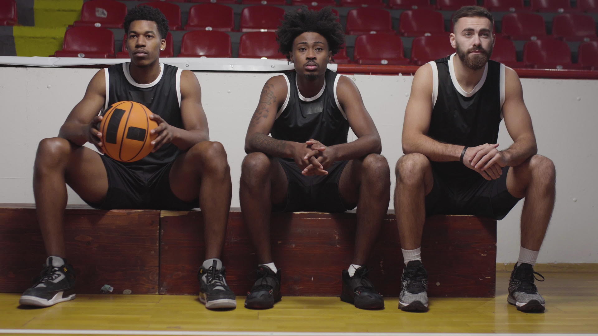 三名篮球运动员坐在板凳上观看比赛欢呼和鼓掌视频的预览图