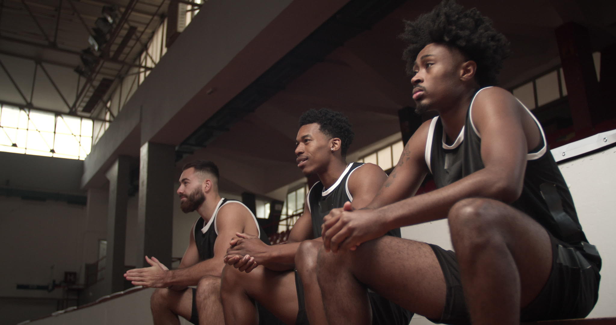 三名篮球运动员坐在板凳上观看比赛欢呼和鼓掌视频的预览图