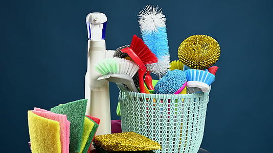 一个装有刷海绵和橡胶手套的塑料篮子用来清洁房子房子旁边是用来清洁的视频的预览图