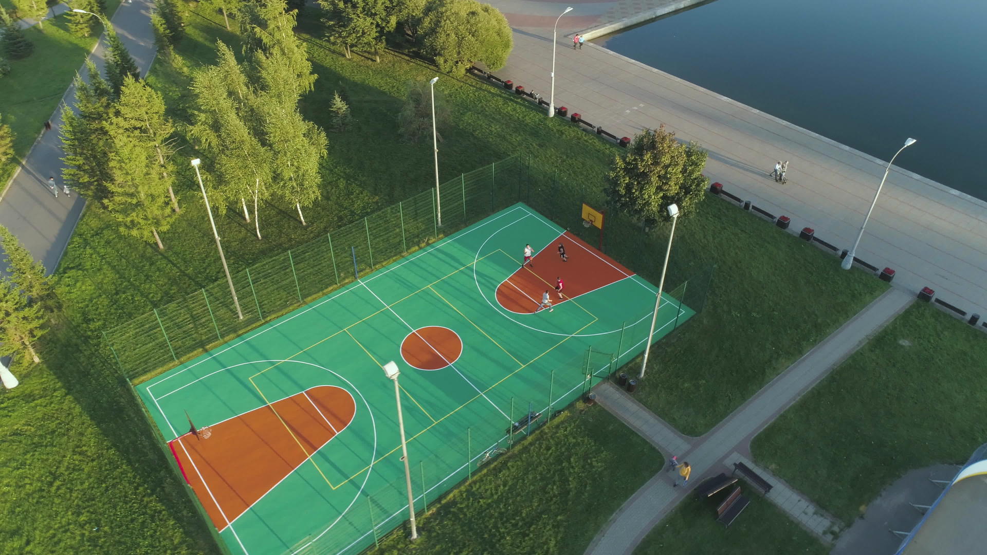 人们在绿色城市公园的球场上打篮球空中视线最高的无人机视频的预览图