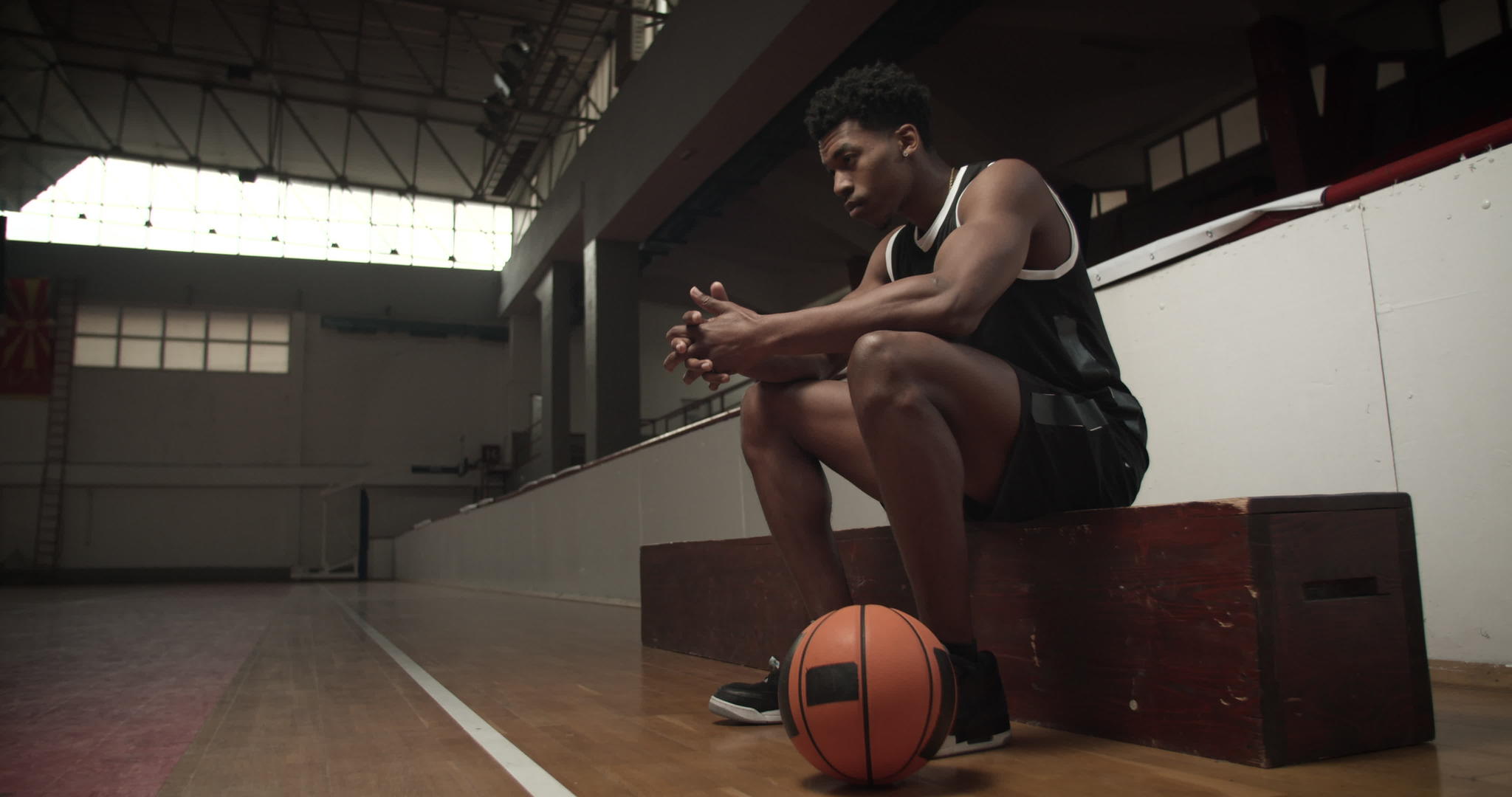 坐在板凳上的篮球运动员严肃而专注视频的预览图