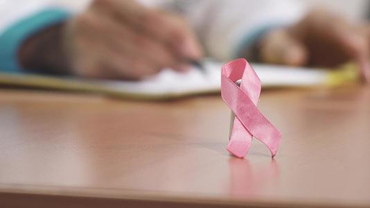 医生桌上的粉红色丝带乳腺癌识别符号；在医生桌上视频的预览图
