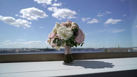 窗户附近的白色和粉色牡丹花束新娘的婚礼花束视频的预览图