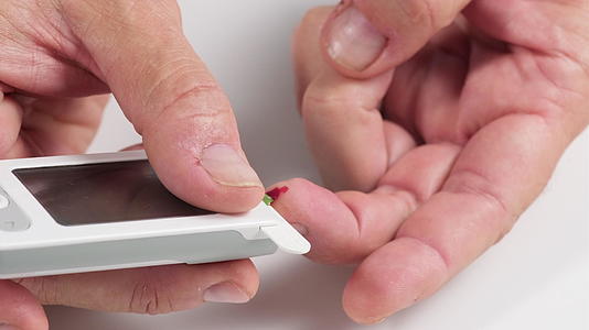从手指取血到测量血糖的过程男人的手拿着显示器视频的预览图