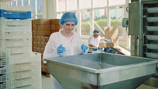 糖果厂工人检查包装机的笑声视频的预览图