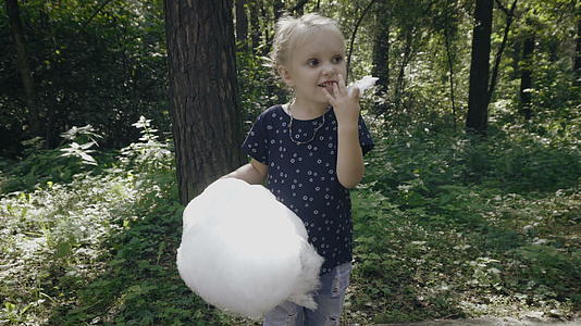可爱的小女孩正在吃棉花糖视频的预览图