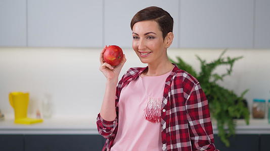 新鲜的苹果手里拿着它穿着格子衬衫留着短发视频的预览图