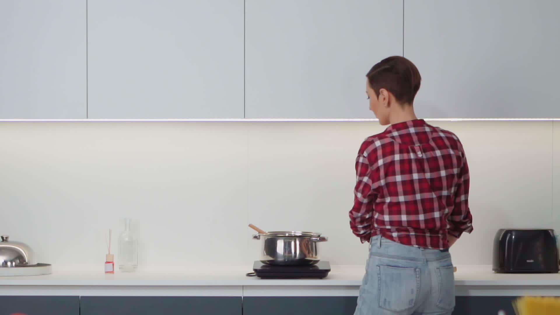 美丽的家庭主妇用一只手站在厨房里做午餐视频的预览图