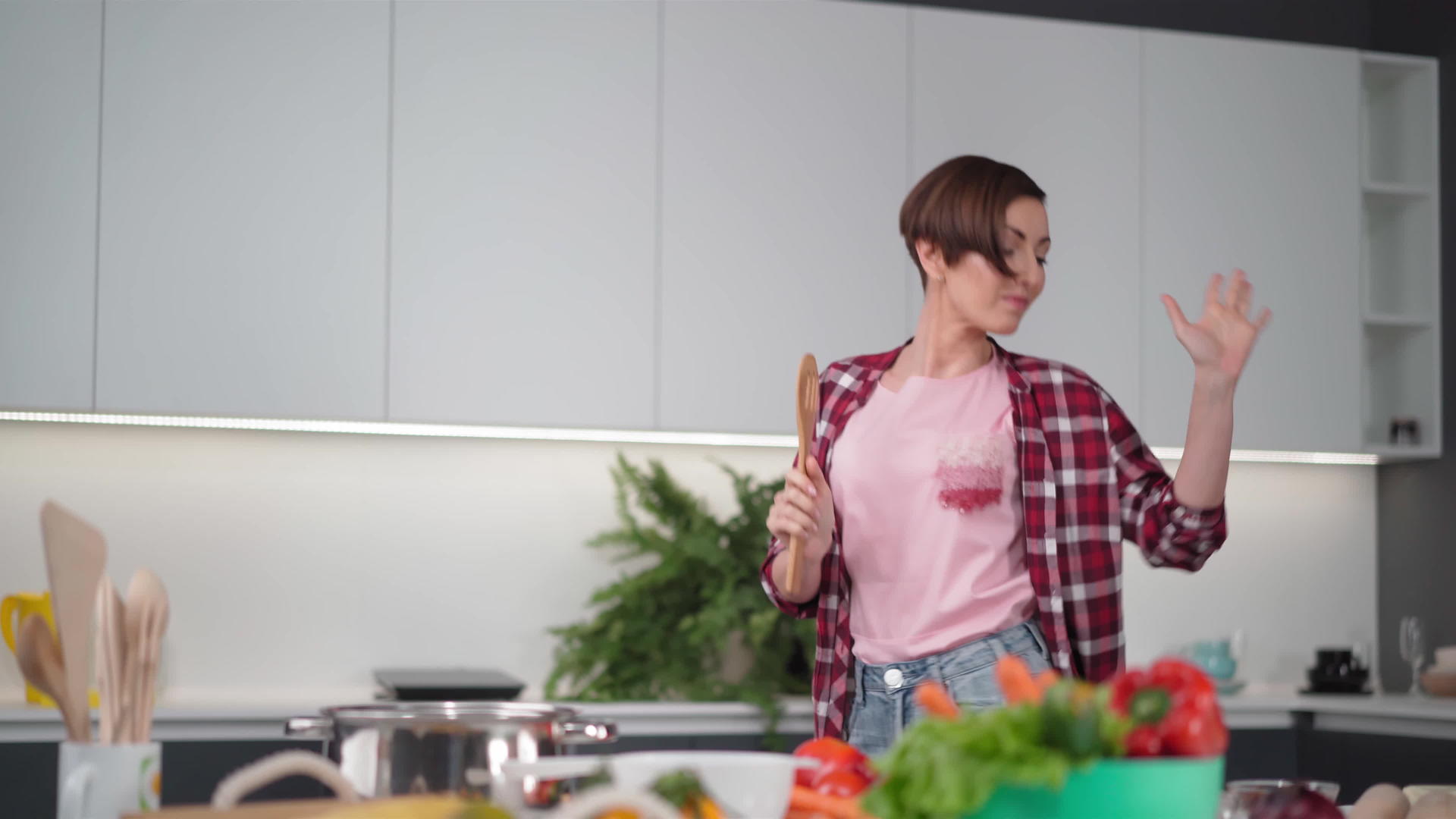 年轻的家庭主妇在厨房跳舞享受生活留着短发站在现代视频的预览图