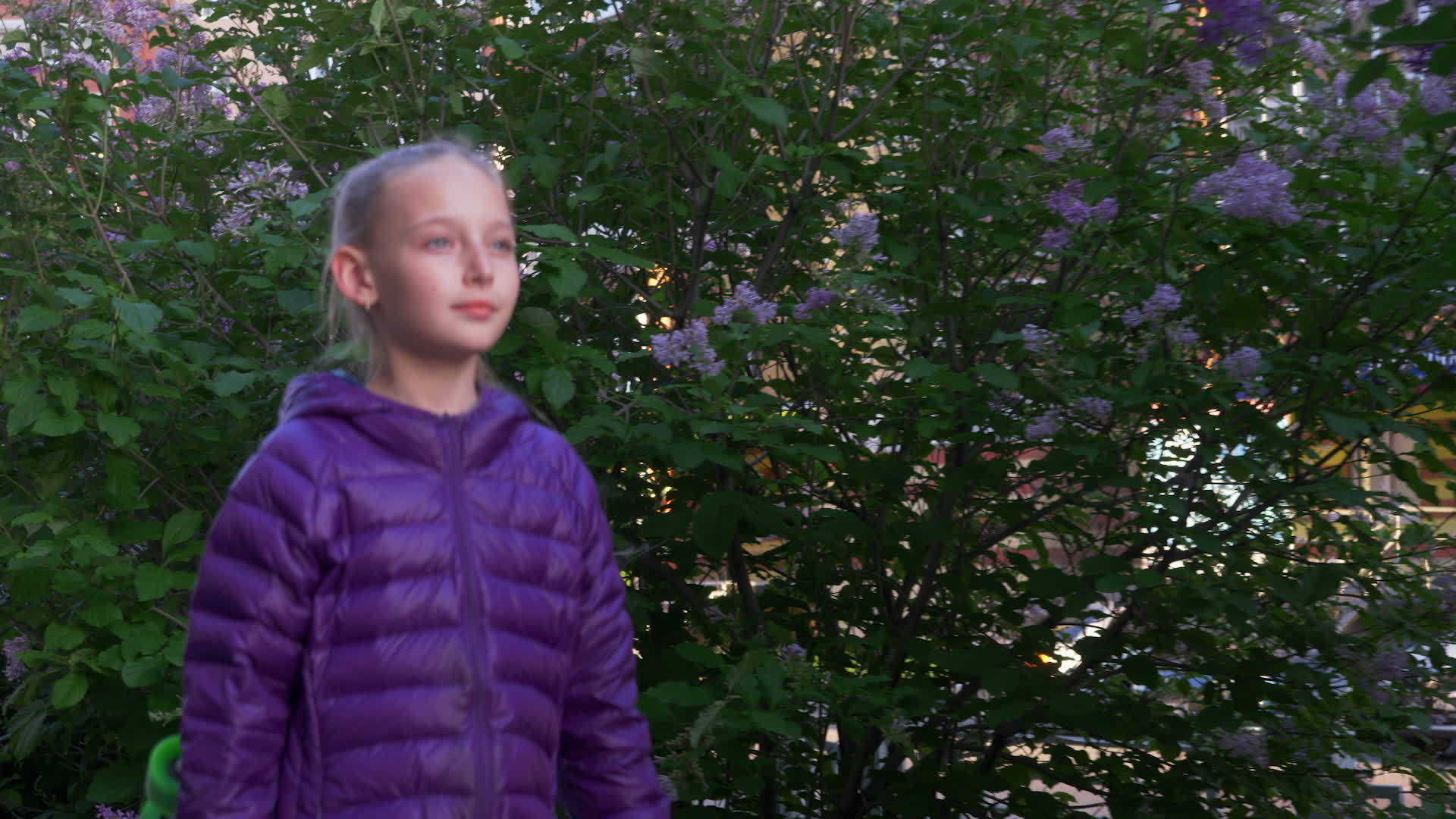 在春天的城市里快乐的女孩手里拿着盛开的丁香树视频的预览图
