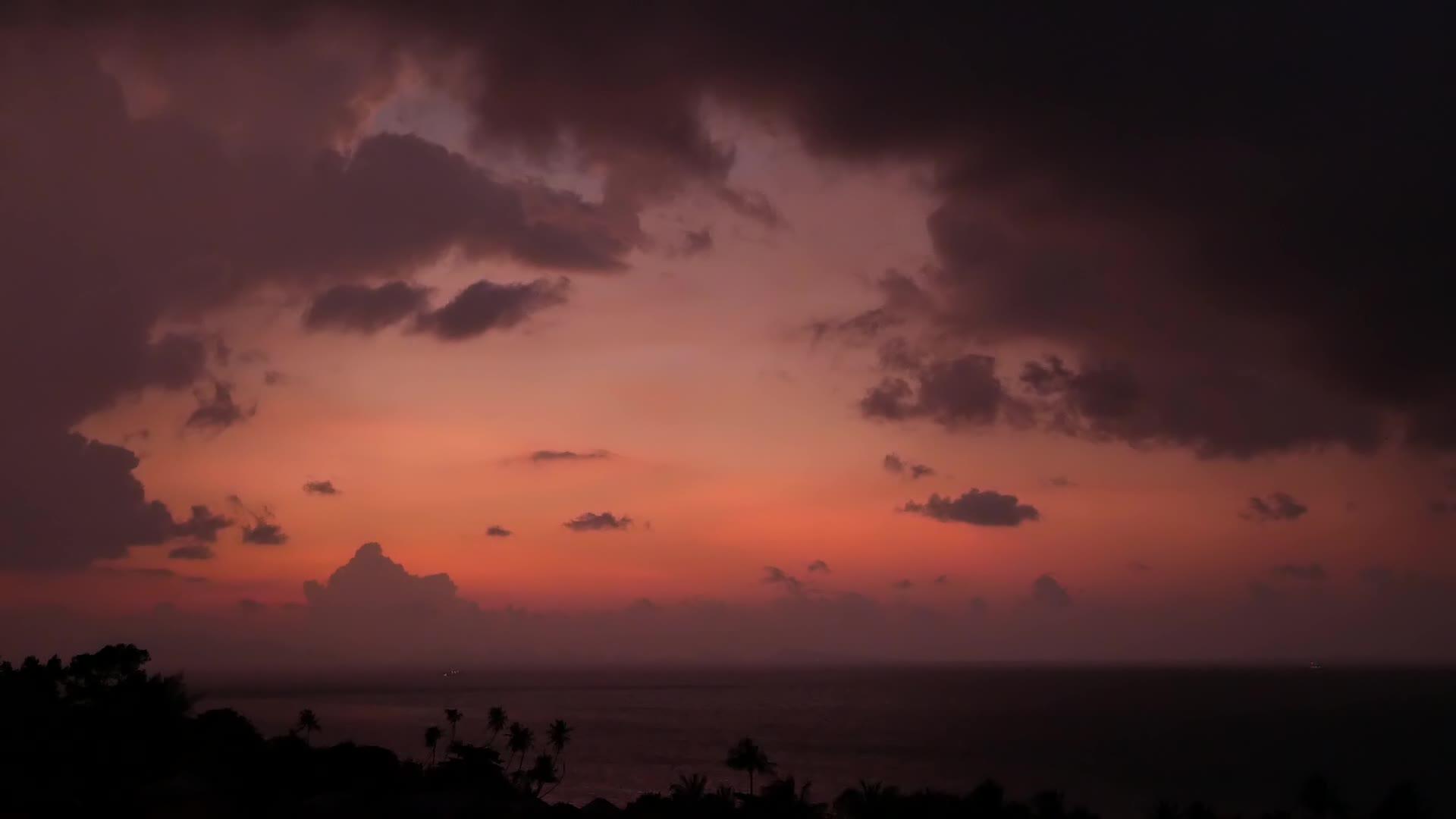 在雄伟的热带紫色夏季游戏中时光倒流日落在海中山在剪影中视频的预览图