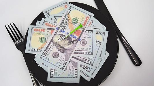 用叉子刀和正面测试在盘子里装满数百美元的钞票视频的预览图