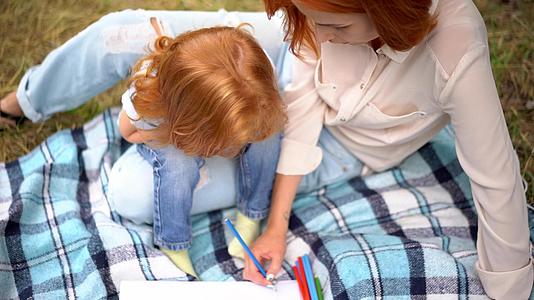 可爱的母亲和孩子在公园里画画视频的预览图
