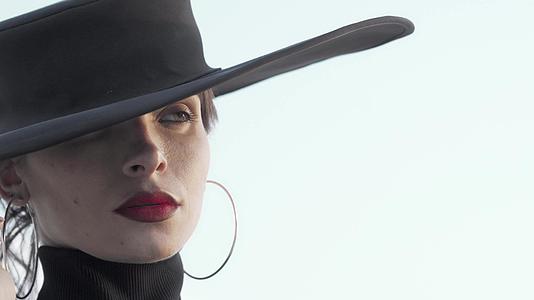 一个戴着黑帽子的漂亮的红脸女人满脑子都是视频的预览图
