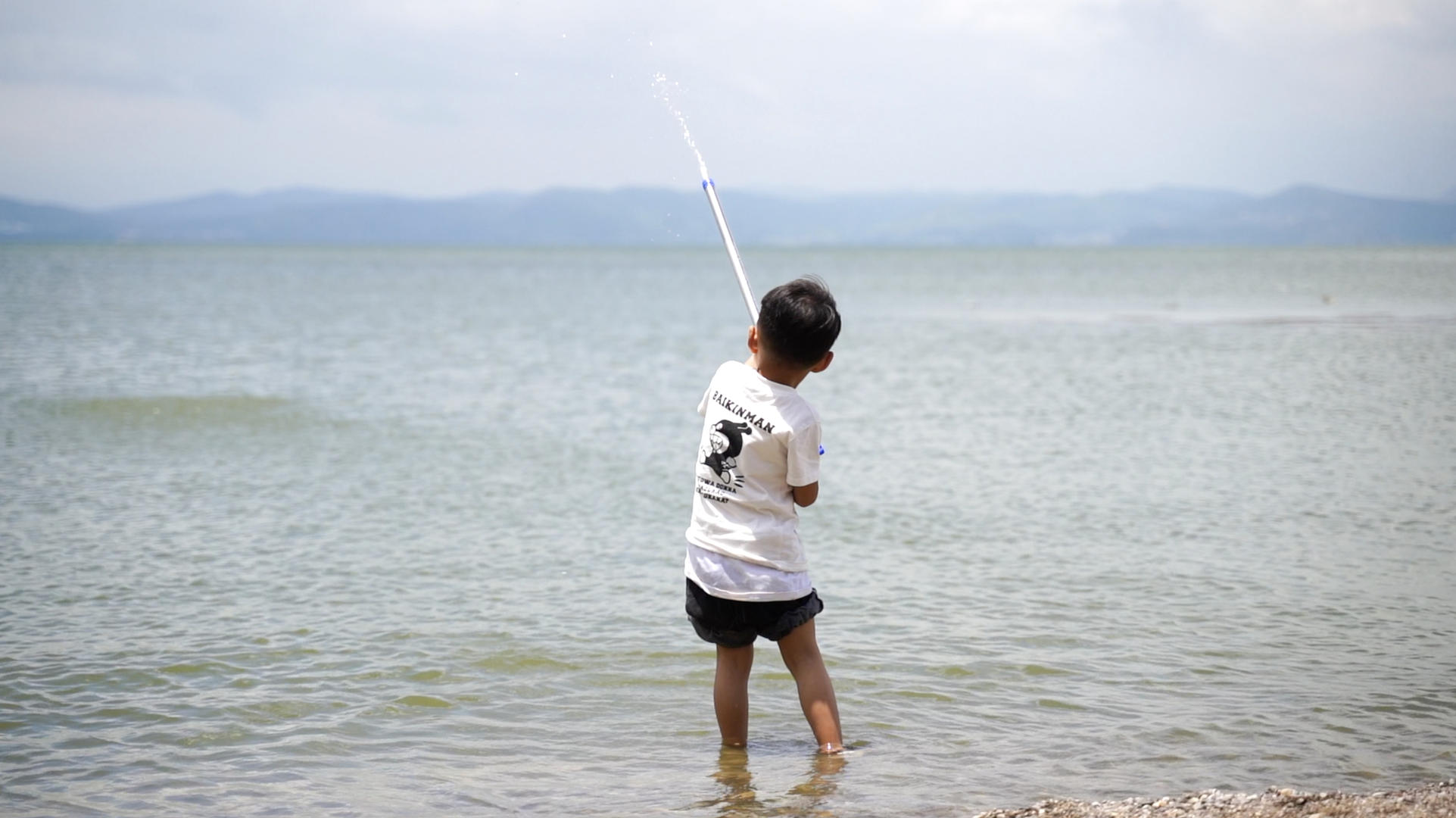 4k升格夏天小孩子在水边玩水枪视频的预览图