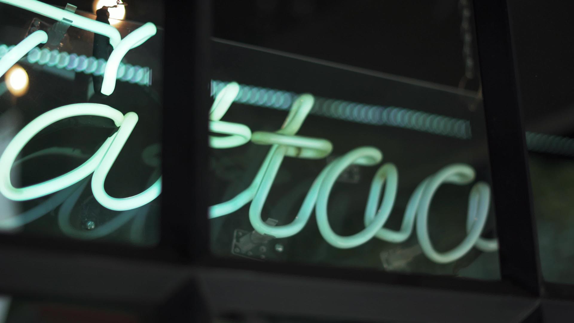 蓝色纹身灯符号在理发店和纹身工作室的窗户上视频的预览图
